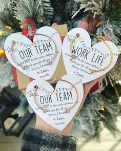 three heart shaped key chains with the words work life and our team printed on them