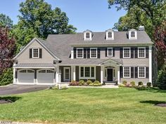 a large gray house with white trim and windows