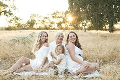 a group of women sitting next to each other on top of a field