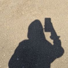 the shadow of a person holding a cell phone