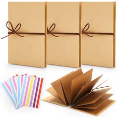 three boxes tied with brown ribbon and four different colored paper cards next to each other