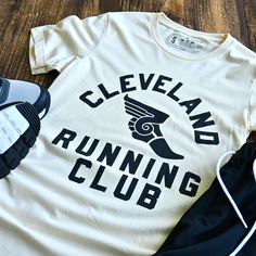 Join the Cleveland Running Club for a fun and quirky workout experience! Connect with fellow runners and explore the city while staying active. Unleash your inner athlete with this heather cream running club shirt. Designed and printed locally in Cleveland on a super soft unisex crewneck heather black tee shirt (52% cotton / 48% poly) Polyester retains shape and elasticity; Cotton lends both comfort and durability. Fits like a well-loved favorite, featuring a crew neck, short sleeves and designe 5k Shirt Design, Running Shirt Design Ideas, Marathon T-shirt, Rawdawg Run Club, Team T Shirt Designs, Gym Merch, Funny Running Shirts, Vintage Running, Run Club