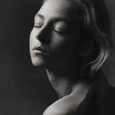 a black and white photo of a woman with her eyes closed