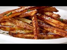 french fries with parmesan cheese and herbs in a white bowl on a table