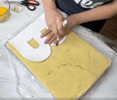 a person cutting out letters on top of a sheet of paper