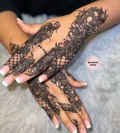 a woman's hands with henna tattoos on them