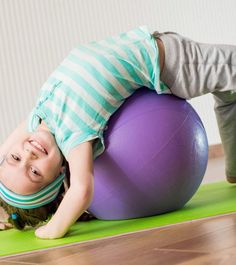 a young boy is doing exercises on an exercise ball while holding his head in the air