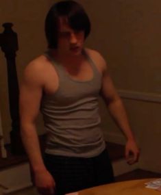 a young man standing in front of a table with a cake on top of it