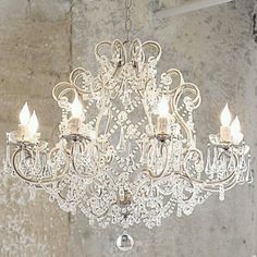 a chandelier hanging from the ceiling in a room with peeling paint on the walls