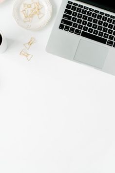 an open laptop computer sitting on top of a desk next to a cup of coffee