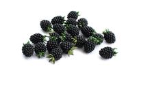 blackberries are scattered on a white surface