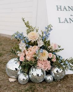 a bouquet of flowers and silver disco balls on the ground