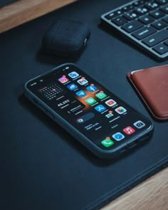 a cell phone sitting on top of a desk next to a keyboard and mouse pad