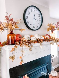 a clock is on the wall above a mantle with fall leaves and pumpkins in front of it