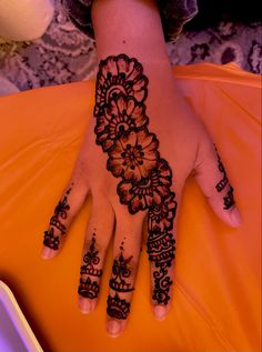 a woman's hand with henna tattoos on it