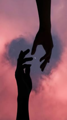 two hands reaching towards each other in front of a pink and blue sky with stars