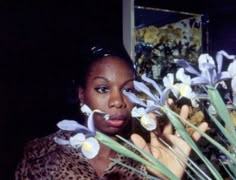 a woman holding flowers in front of her face