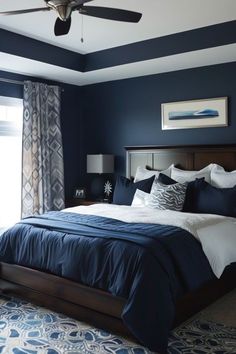 a bedroom with blue walls and white bedding in the center, along with a ceiling fan