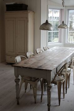 an old wooden table with chairs around it