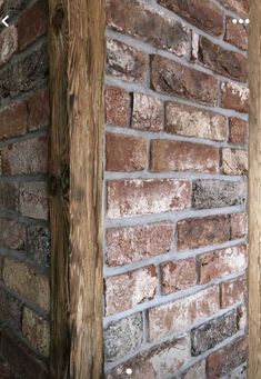 the corner of a brick wall made from wood and stone bricks, with a computer desk in the background