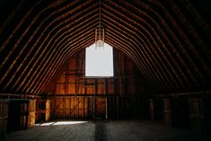 the inside of an old barn with wooden walls and beams on the ceiling is very dark