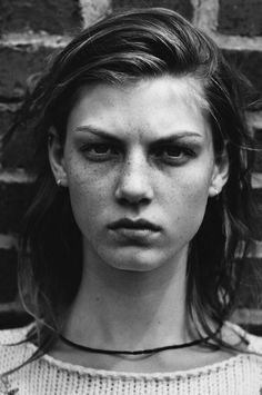 a black and white photo of a woman with freckles on her face