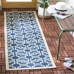 a blue and white rug sitting on top of a wooden floor next to a chair