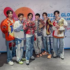 the group of boys are posing together for a photo in front of a large sign