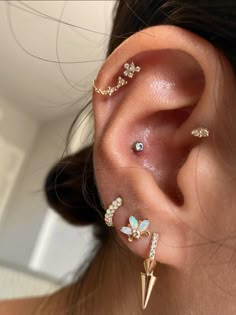 a woman's ear with three different piercings