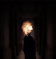 a person with blonde hair standing in a dark hallway, looking at the light coming through their eyes