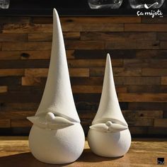 two white vases sitting on top of a wooden table