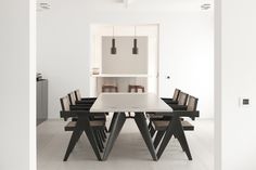 a dining room table and chairs with white walls