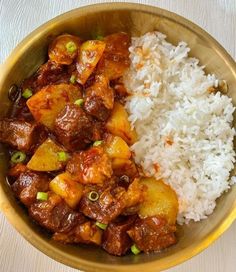 a bowl filled with rice and meat on top of a table