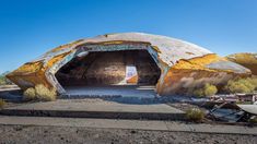 an abandoned building in the desert with graffiti on it's walls and roof,