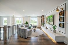 a living room filled with furniture and a large window next to a stair case in front of it