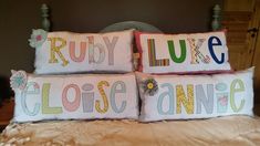 two pillows that say ruby, luke, close annie and lily on them sitting on a bed