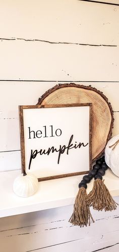 there is a sign that says hello pumpkin on the shelf next to some yarn balls