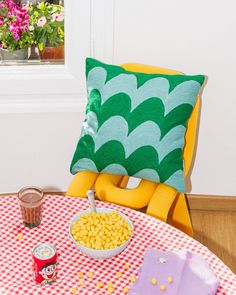 a bowl of cereal sits on a table next to a pillow