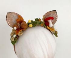 a headband with flowers and leaves on top of a mannequin's head