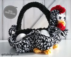 a crocheted basket with an egg in it and a chicken on the handle