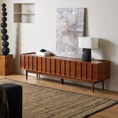 a living room with a large painting on the wall next to a wooden entertainment center