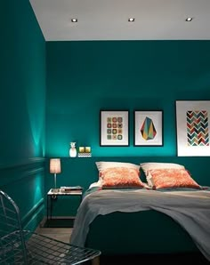 a bedroom with green walls and pictures on the wall