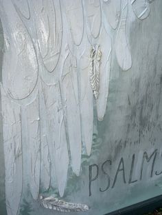 an artistic painting on the side of a building with white wings and words painted on it