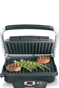 an electric grill with asparagus and steak on it