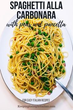 spaghetti alla carbonara with peas and pancetta in a white bowl on a plate