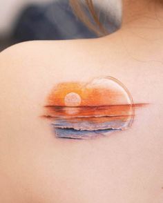 the back of a woman's shoulder with an abstract sunset tattoo on her left shoulder