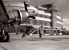 an airplane parked in front of a large building