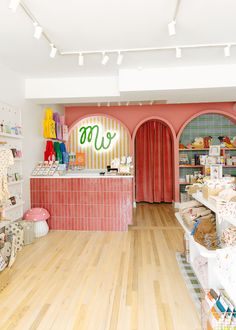 the inside of a children's clothing store with wooden floors and shelves filled with toys