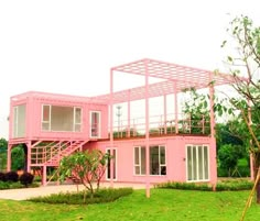 a pink house is in the middle of a grassy area