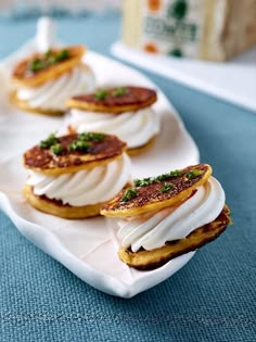 small appetizers are arranged on a white platter, ready to be eaten